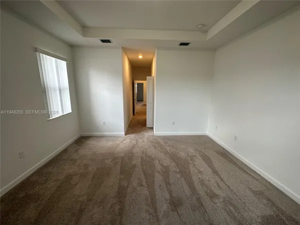 an empty room with windows and closet