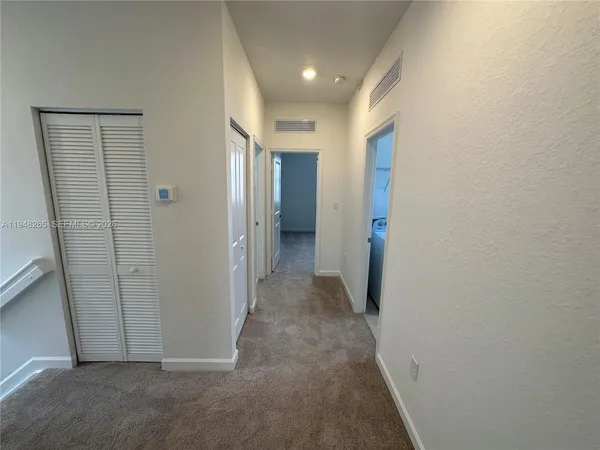 a view of a hallway with wooden shelves