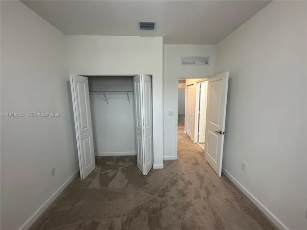 an empty room with windows and closet