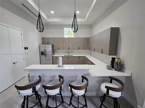 a kitchen with a dining table chairs sink and white cabinets