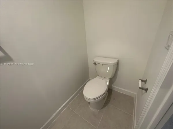 a white toilet sitting next to a white wall