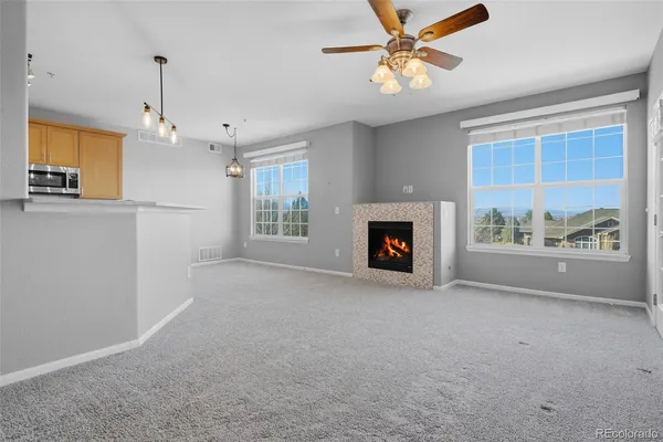 a view of livingroom with fireplace window and a ceiling fan