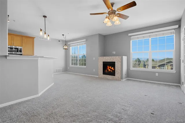 a view of livingroom with fireplace window and a ceiling fan
