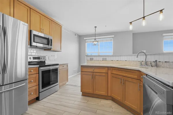 a kitchen with granite countertop a sink stainless steel appliances and cabinets