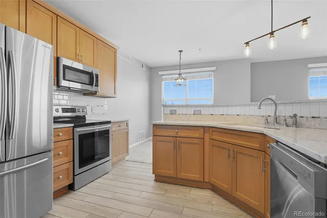 a kitchen with granite countertop a sink stainless steel appliances and cabinets