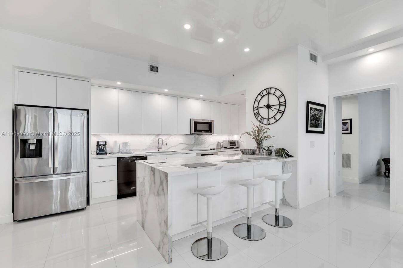 3131 Northeast 188th Street, Unit 21004 Aventura, FL 33180 - Photo 11 of 53 a kitchen with stainless steel appliances granite countertop a sink and a refrigerator