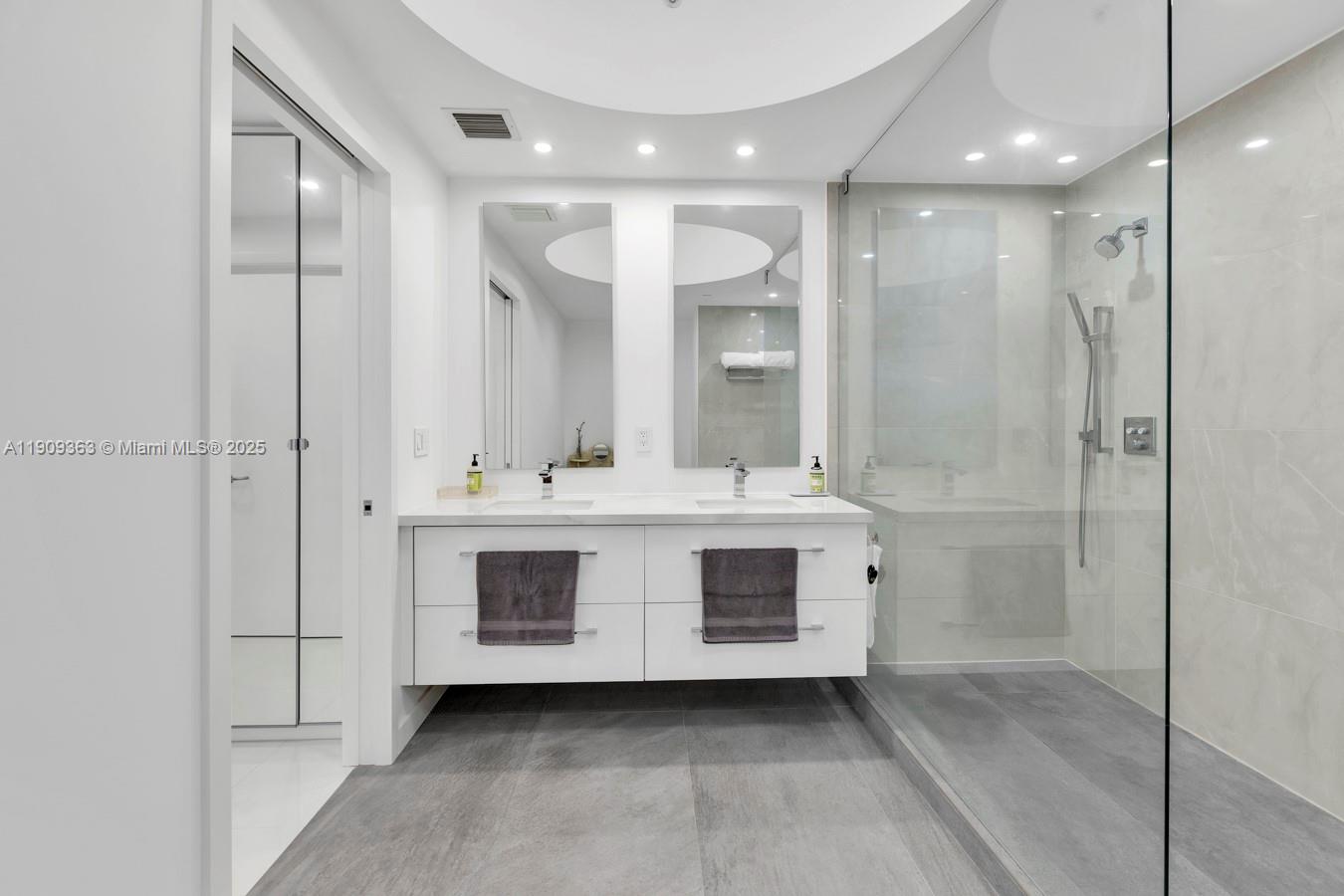 3131 Northeast 188th Street, Unit 21004 Aventura, FL 33180 - Photo 27 of 53 a bathroom with a double vanity sink mirror and shower