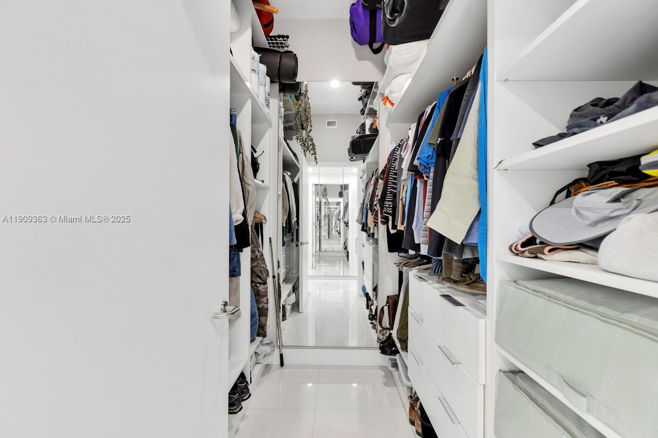3131 Northeast 188th Street, Unit 21004 Aventura, FL 33180 - Photo 30 of 53 a view of walk in closet with clothes and shoes