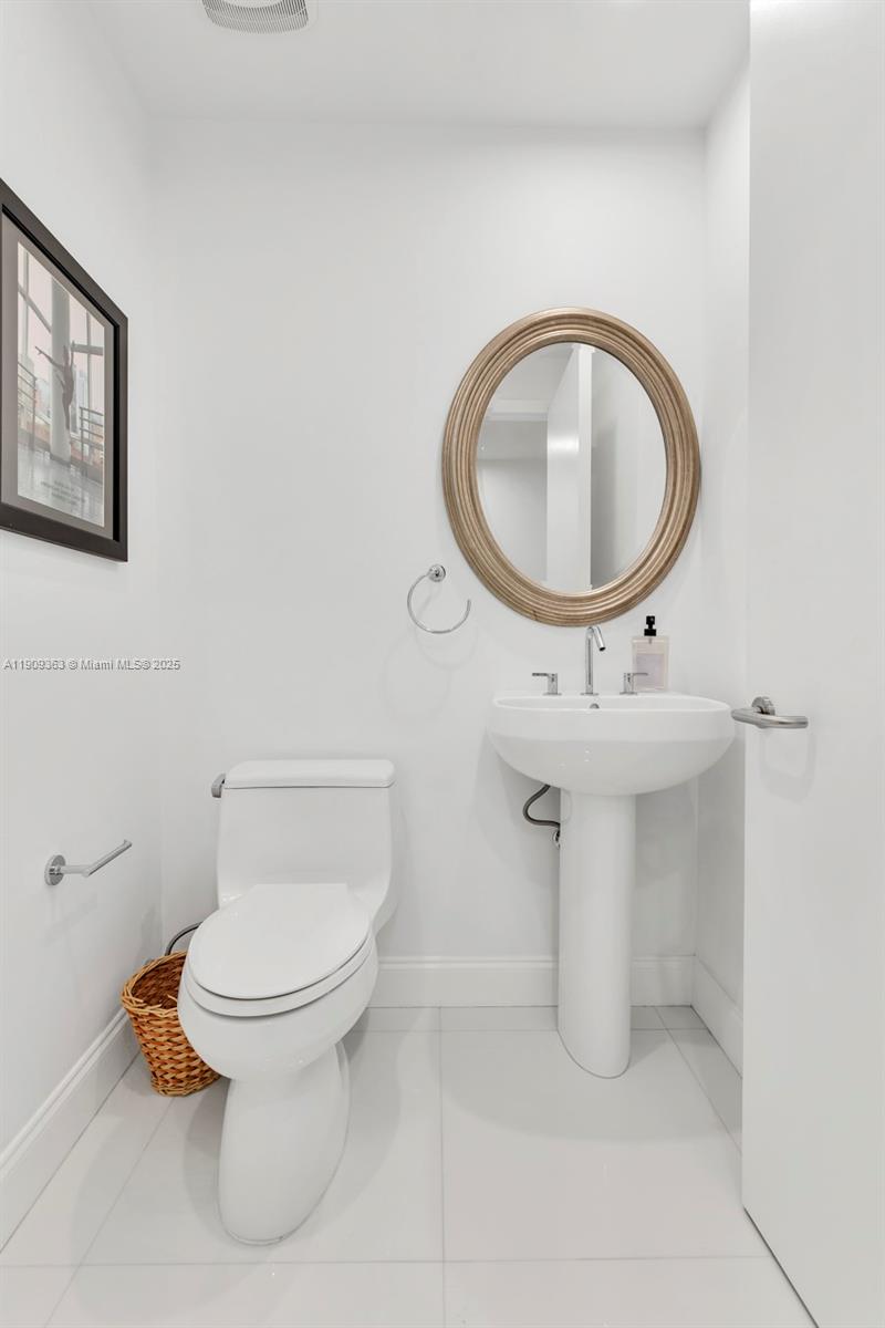 3131 Northeast 188th Street, Unit 21004 Aventura, FL 33180 - Photo 32 of 53 a bathroom with a toilet sink and mirror