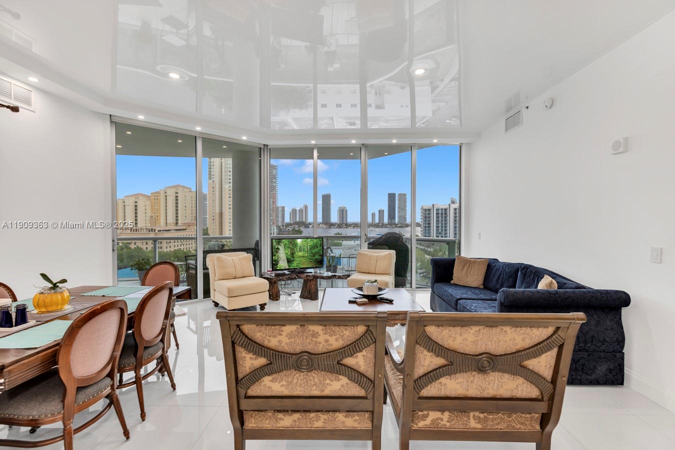 3131 Northeast 188th Street, Unit 21004 Aventura, FL 33180 - Photo 8 of 53 a view of a dining room with furniture a kitchen and chandelier