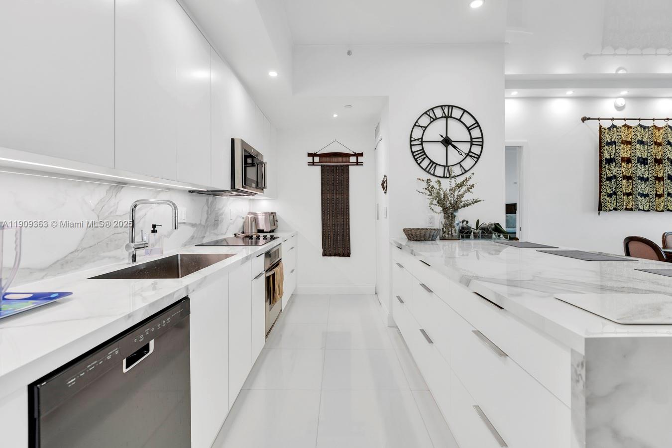 3131 Northeast 188th Street, Unit 21004 Aventura, FL 33180 - Photo 9 of 53 a large white kitchen with a sink and a stove top oven