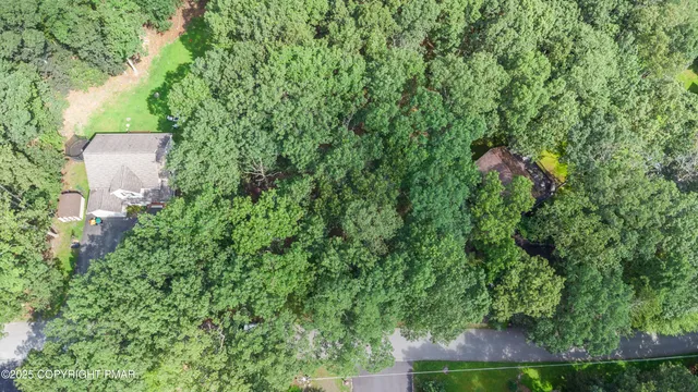 an aerial view of a house with a yard and outdoor seating