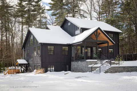 a view of a house with a yard covered in snow