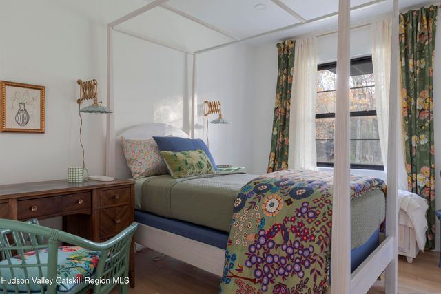 a view of a room with a large window and wooden floor