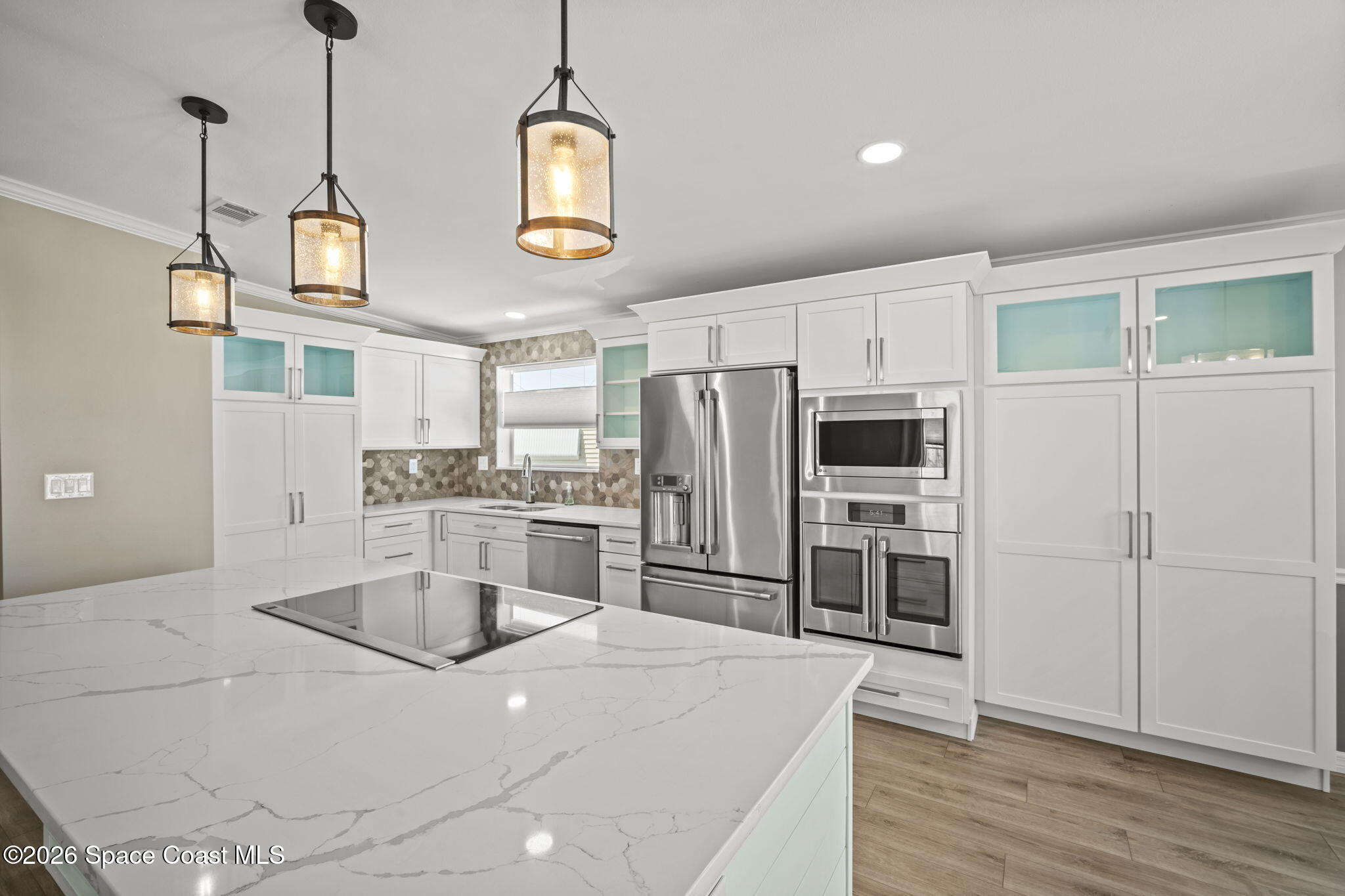 2966 Indian River Drive Northeast Palm Bay, FL 32905 - Photo 12 of 31 a kitchen with kitchen island white cabinets and stainless steel appliances