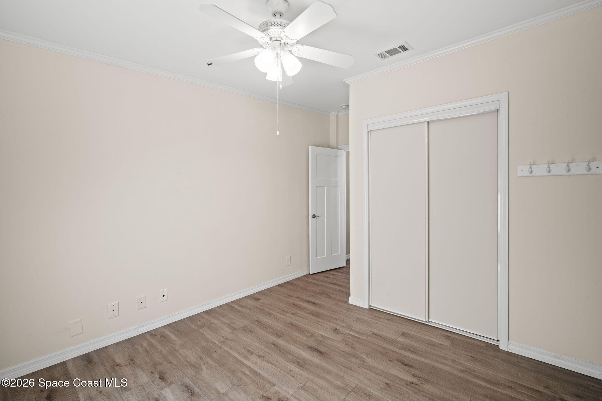 2966 Indian River Drive Northeast Palm Bay, FL 32905 - Photo 20 of 31 an empty room with wooden floor and fan