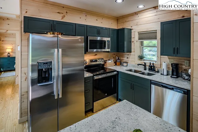 a kitchen with stainless steel appliances granite countertop a refrigerator and a sink