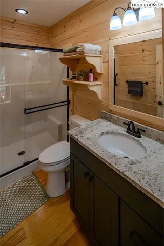 a bathroom with a granite countertop sink toilet and shower