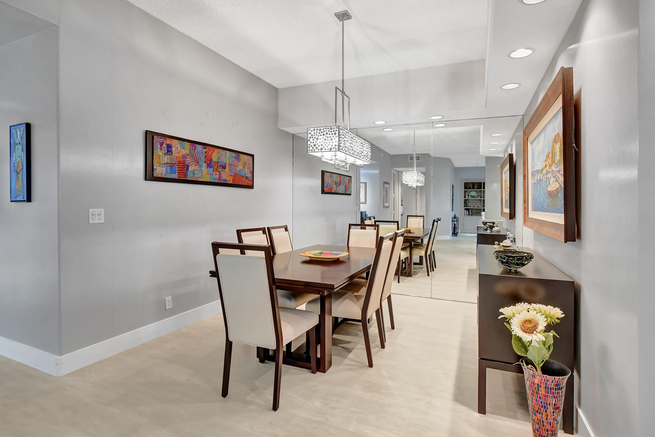 5801 Northwest 24th Avenue, Unit 1004 Boca Raton, FL 33496 - Photo 14 of 65 a view of a dining room and livingroom with furniture wooden floor a rug a painting and a chandelier