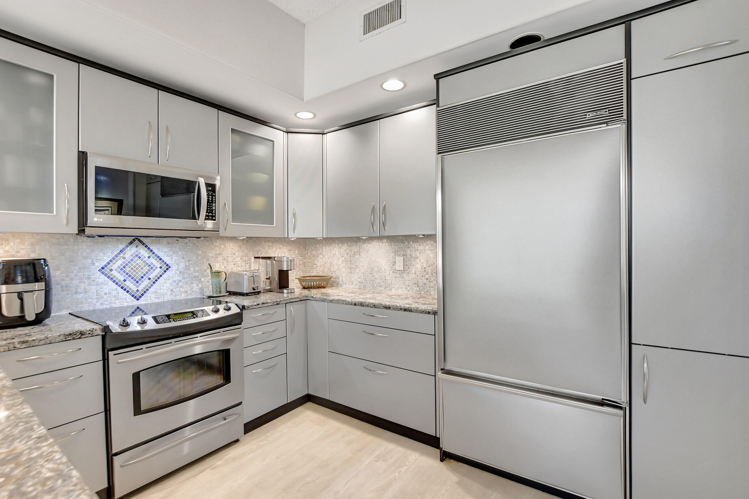 5801 Northwest 24th Avenue, Unit 1004 Boca Raton, FL 33496 - Photo 16 of 65 a kitchen with stainless steel appliances a stove microwave and sink