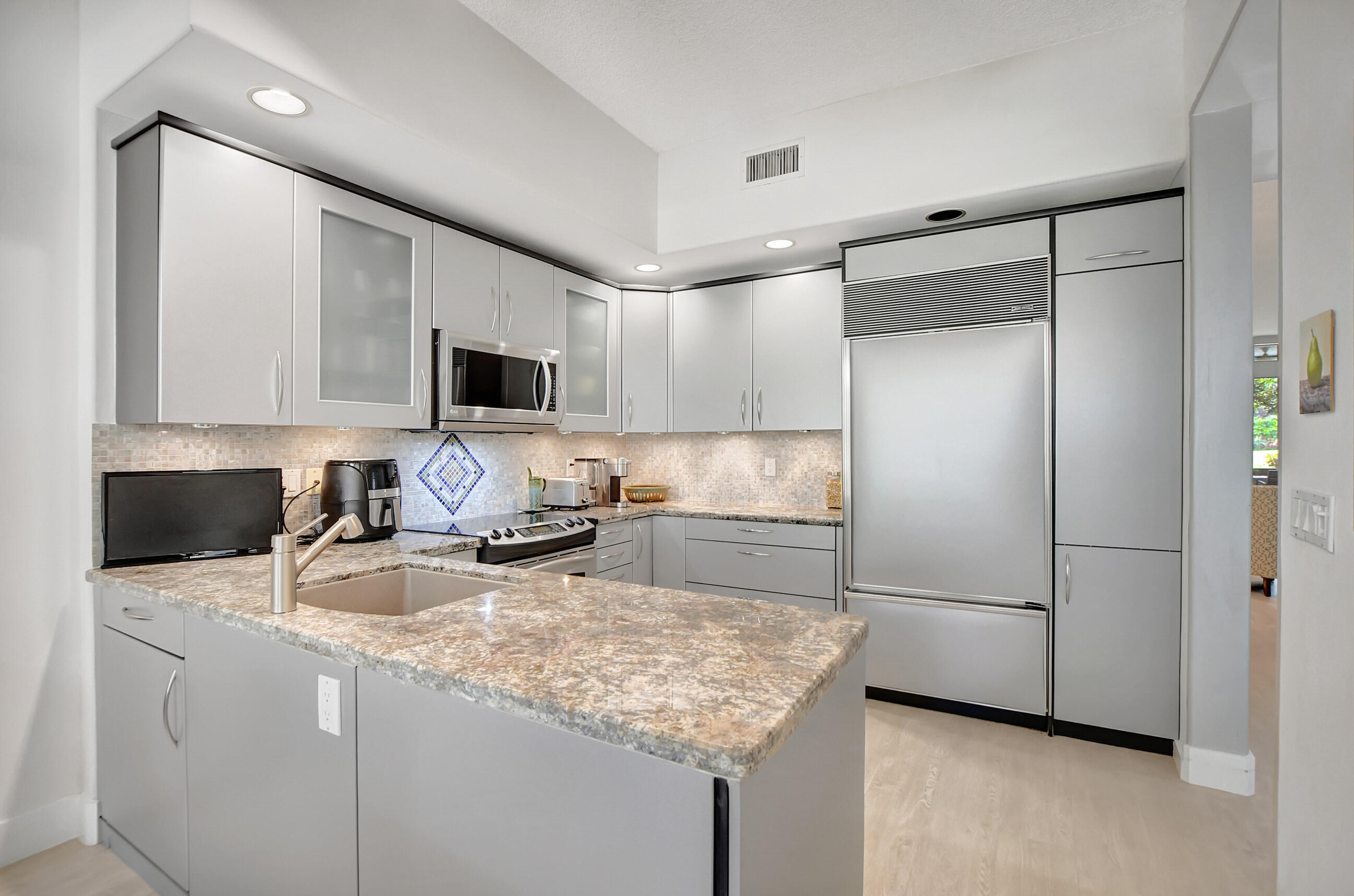 5801 Northwest 24th Avenue, Unit 1004 Boca Raton, FL 33496 - Photo 17 of 65 a kitchen with stainless steel appliances granite countertop a sink refrigerator and microwave