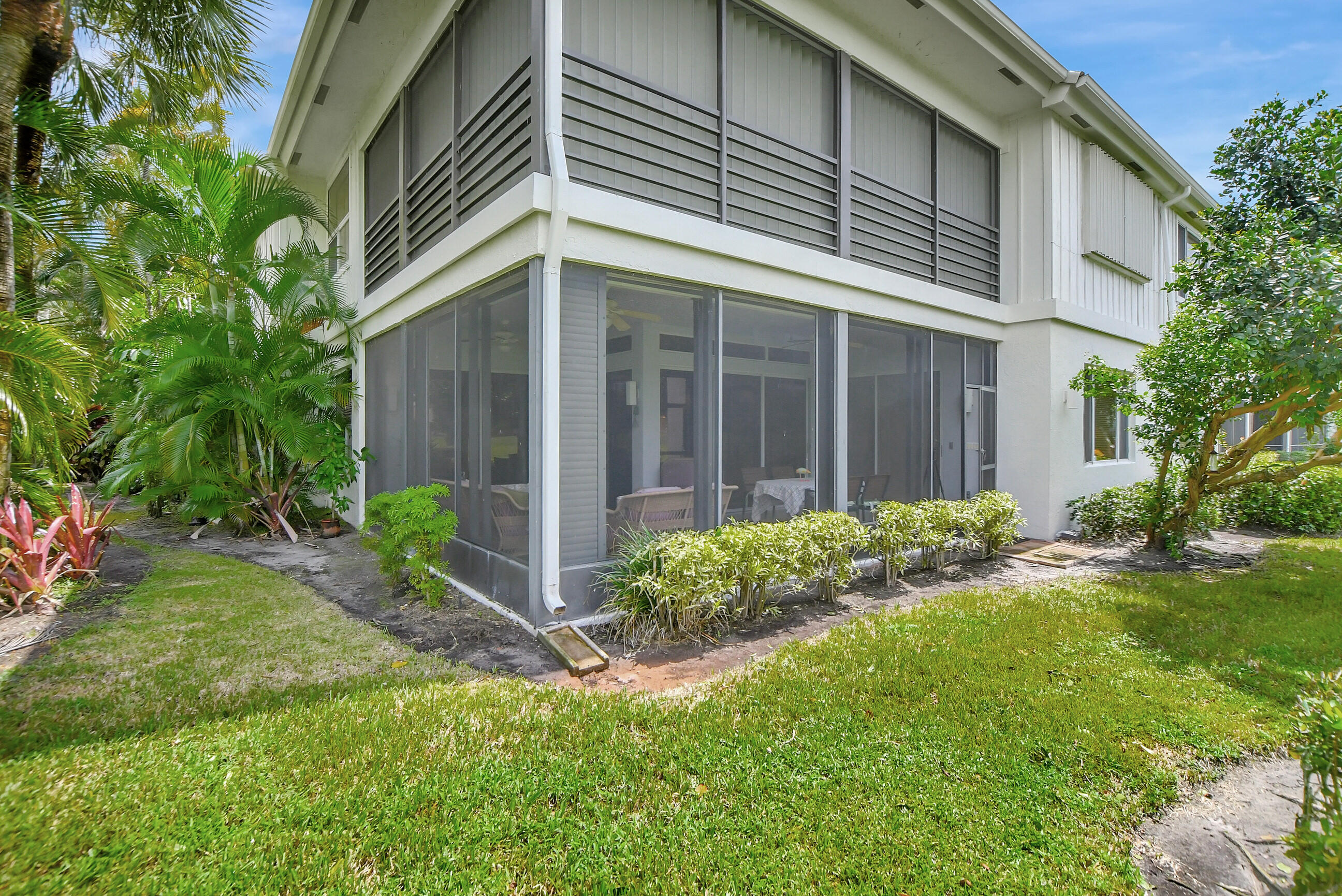 5801 Northwest 24th Avenue, Unit 1004 Boca Raton, FL 33496 - Photo 29 of 65 a view of a house with brick walls and a yard with plants