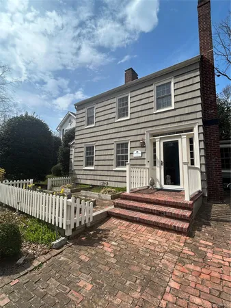 a back view of a house with a small yard and wooden fence
