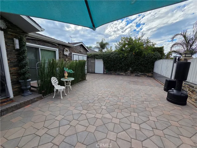 a view of a patio with table and chairs under an umbrella