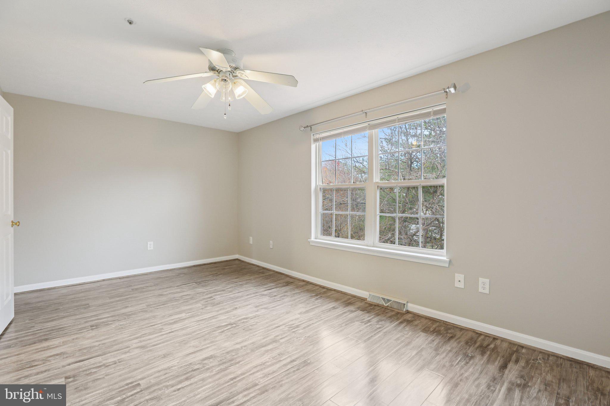 4642 Marksman Court Hampstead, MD 21074 - Photo 14 of 35 an empty room with wooden floor fan and windows