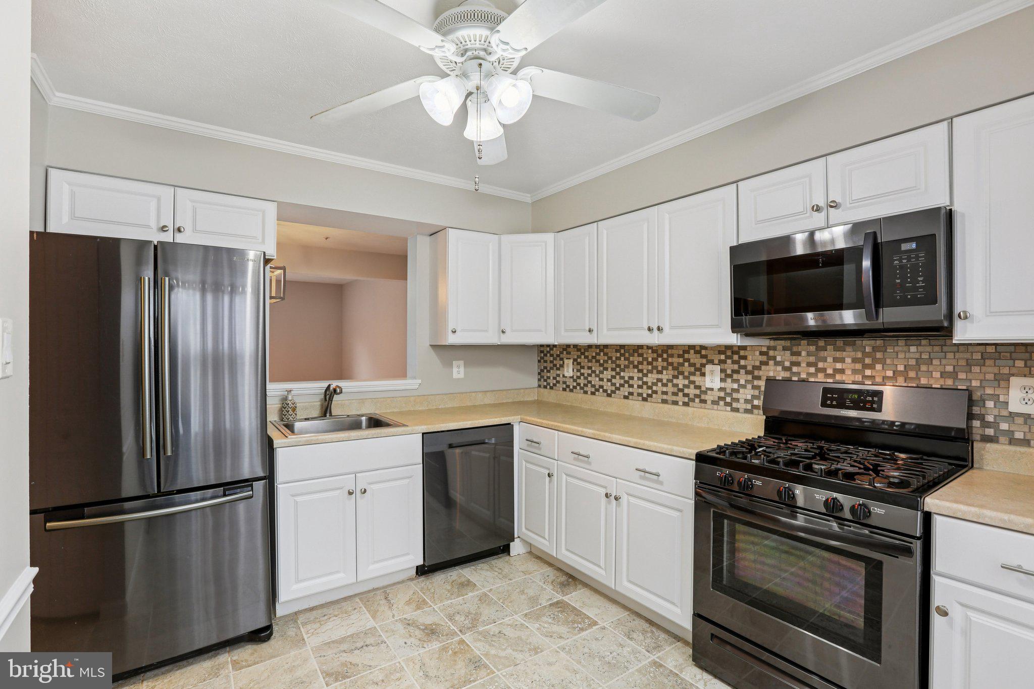 4642 Marksman Court Hampstead, MD 21074 - Photo 8 of 35 a kitchen with stainless steel appliances a refrigerator stove and microwave