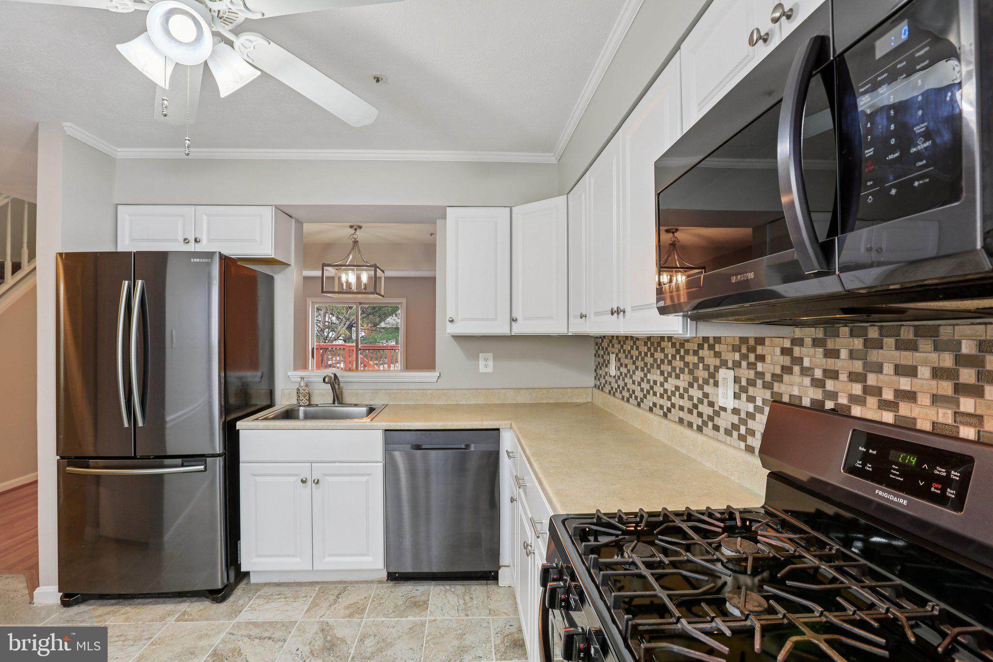 4642 Marksman Court Hampstead, MD 21074 - Photo 9 of 35 a kitchen with a stove a sink and a refrigerator