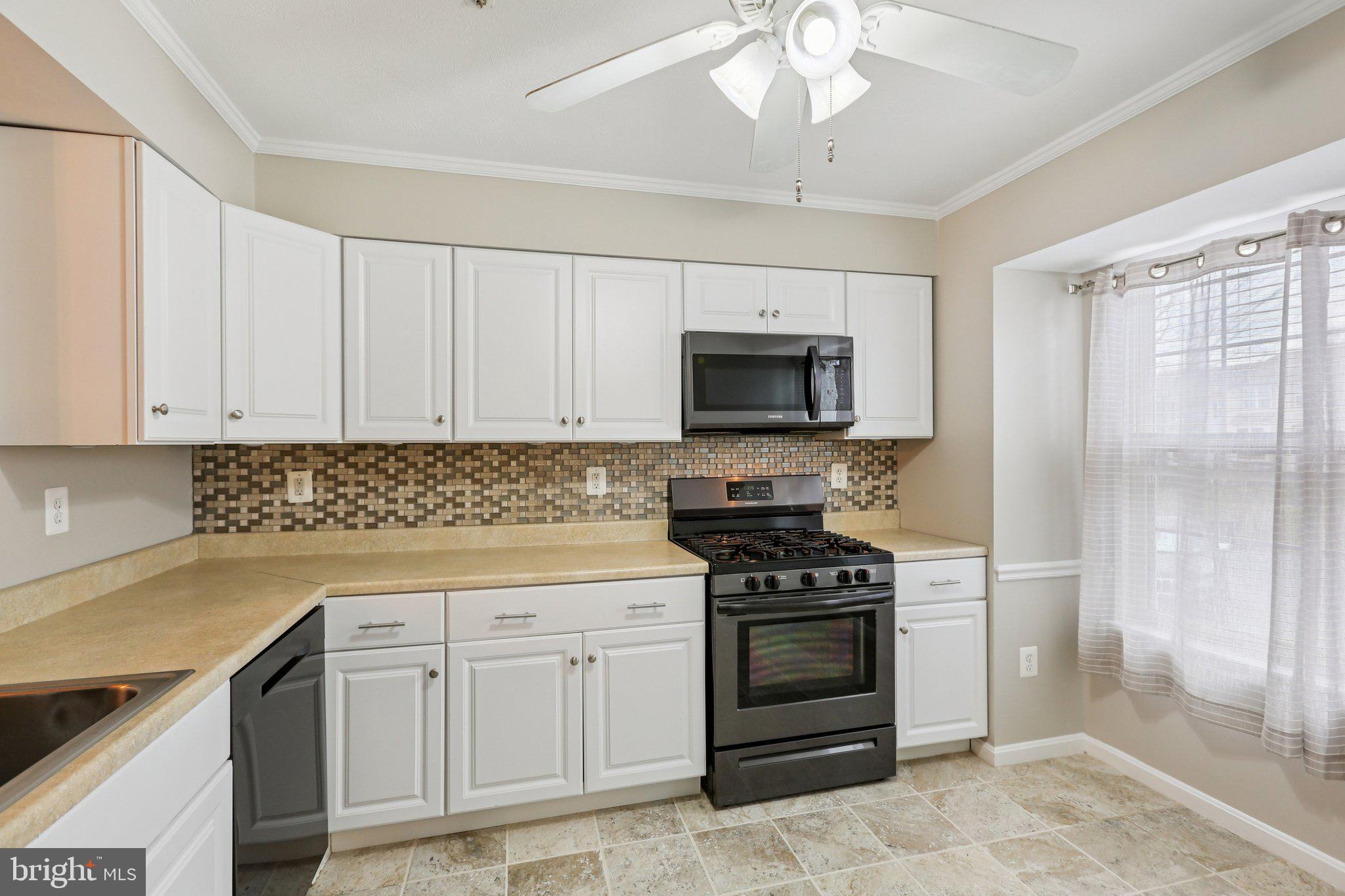4642 Marksman Court Hampstead, MD 21074 - Photo 10 of 35 a kitchen with white cabinets and appliances