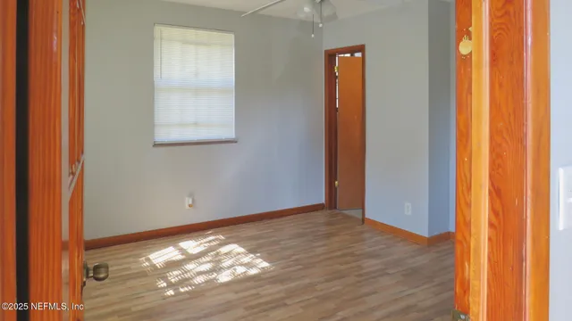 an empty room with wooden floor and windows
