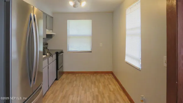 a view of a room with wooden floor and a window