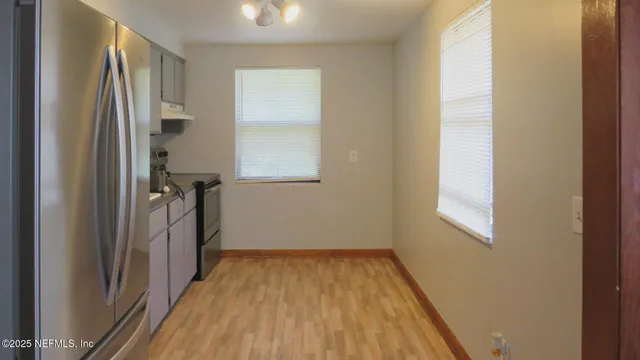 a view of a room with wooden floor and a window