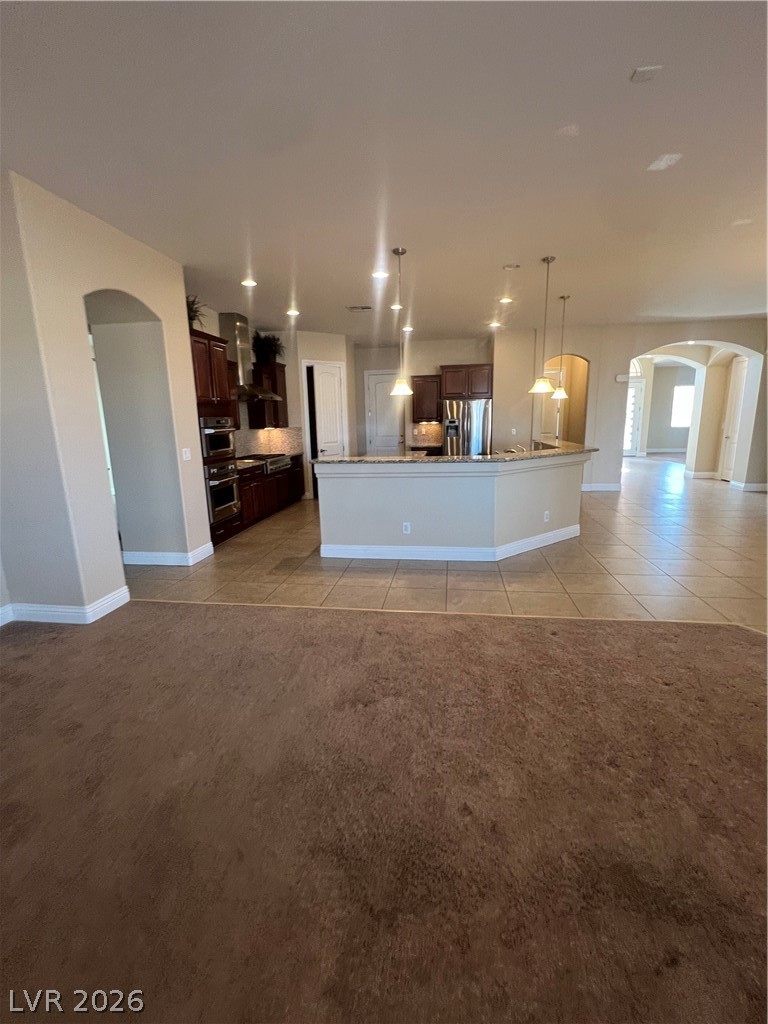 Undisclosed Address Las Vegas, NV 89129 - Photo 33 of 33 Kitchen featuring arched walkways, open floor plan, light tile patterned floors, and hanging light fixtures