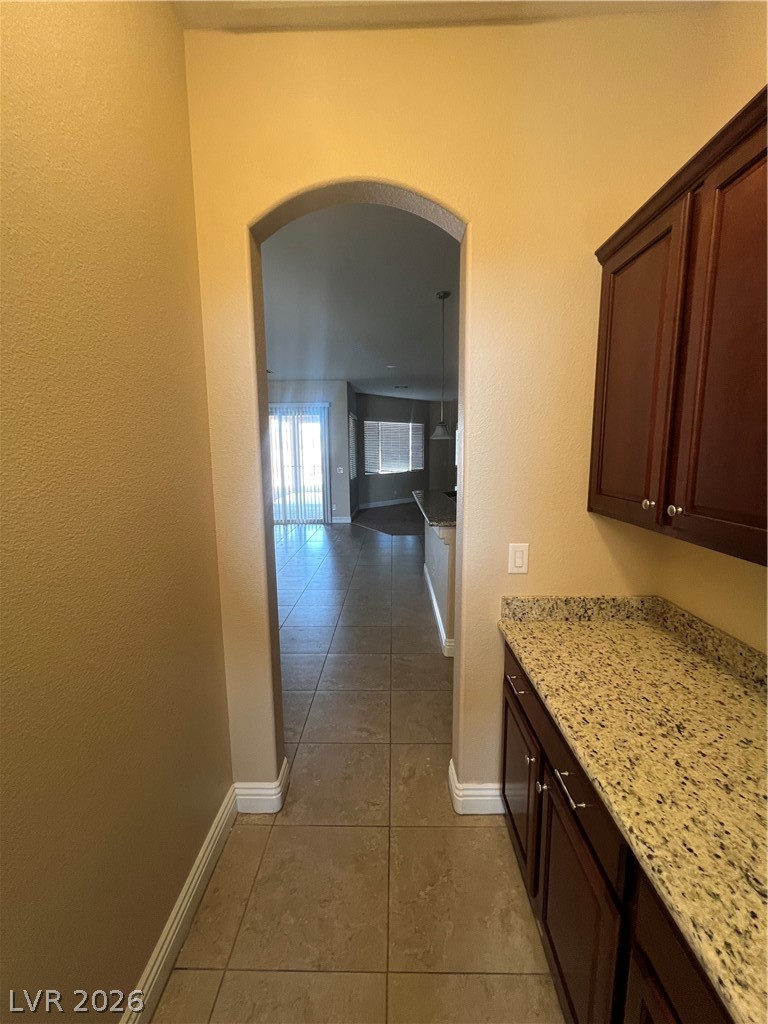 Undisclosed Address Las Vegas, NV 89129 - Photo 27 of 33 Hallway featuring arched walkways, light tile patterned floors, and a textured wall