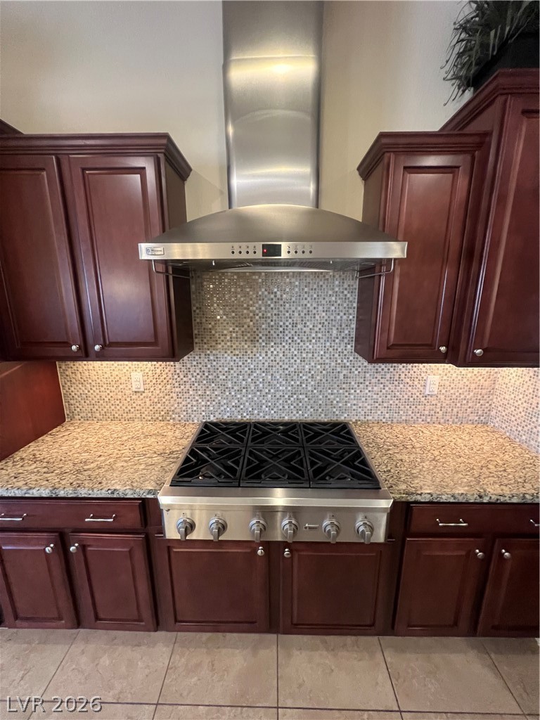 Undisclosed Address Las Vegas, NV 89129 - Photo 28 of 33 Kitchen featuring exhaust hood, stovetop, backsplash, and light stone countertops