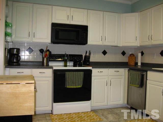 6455 New Market Way Raleigh, NC 27615 - Photo 6 of 18 a kitchen with stainless steel appliances granite countertop white cabinets and a stove