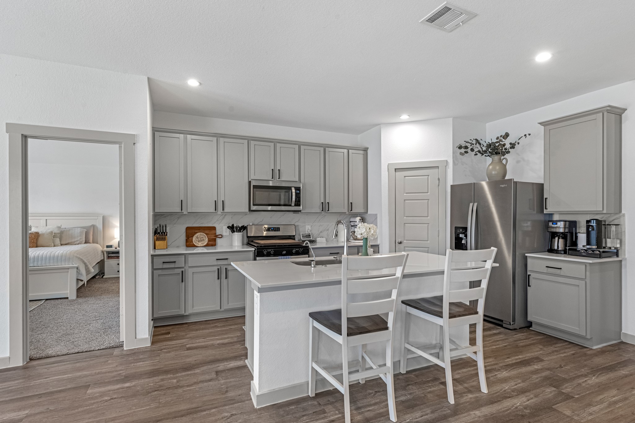 1103 Texel Street Rosharon, TX 77583 - Photo 6 of 33 a kitchen with white cabinets and stainless steel appliances