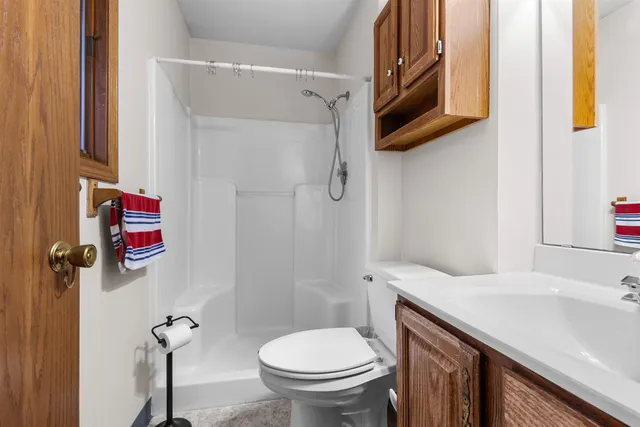a bathroom with a granite countertop sink toilet and shower