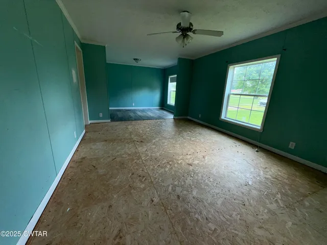 a view of a livingroom with a ceiling fan and window