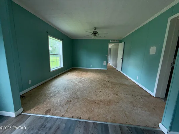 an empty room with windows and kitchen view