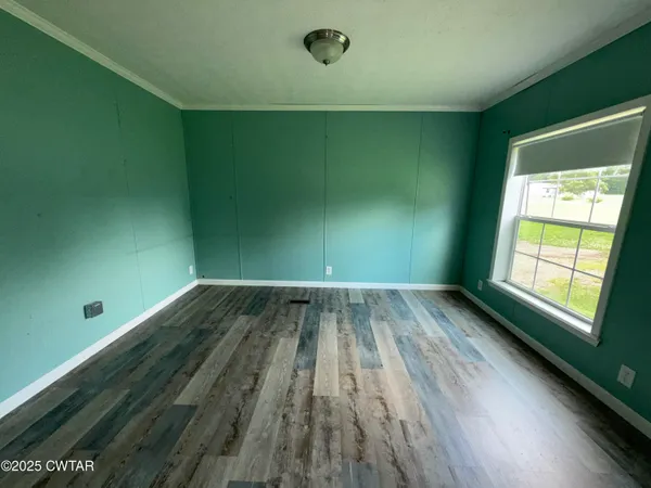 a view of a room with wooden floor and windows