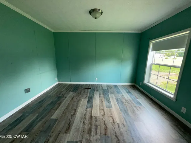 a view of a room with wooden floor and windows