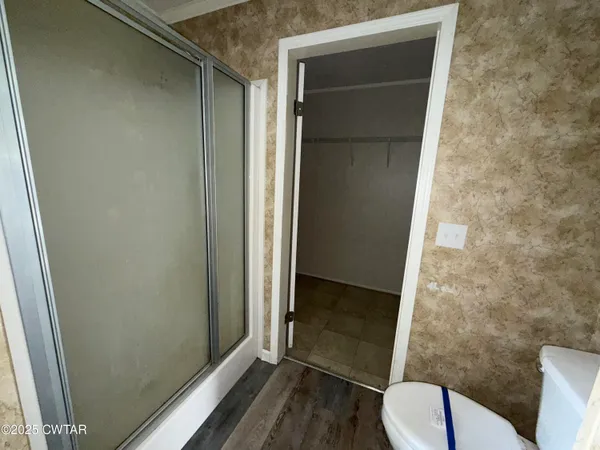 a bathroom with a toilet and a shower