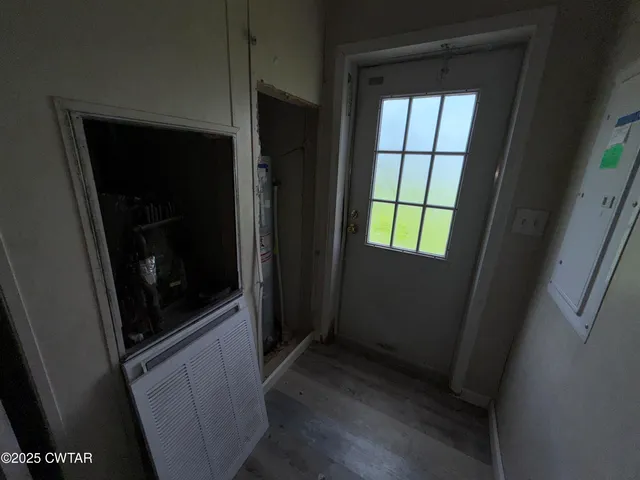 a view of hallway with window and wooden floor