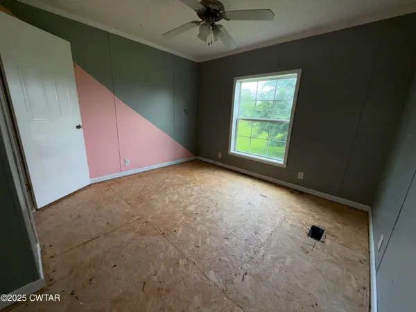 a view of a livingroom with a ceiling fan and window