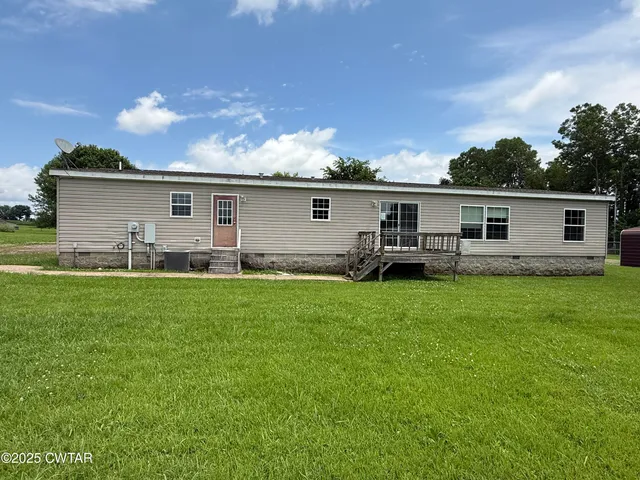 a view of a house with backyard and chairs