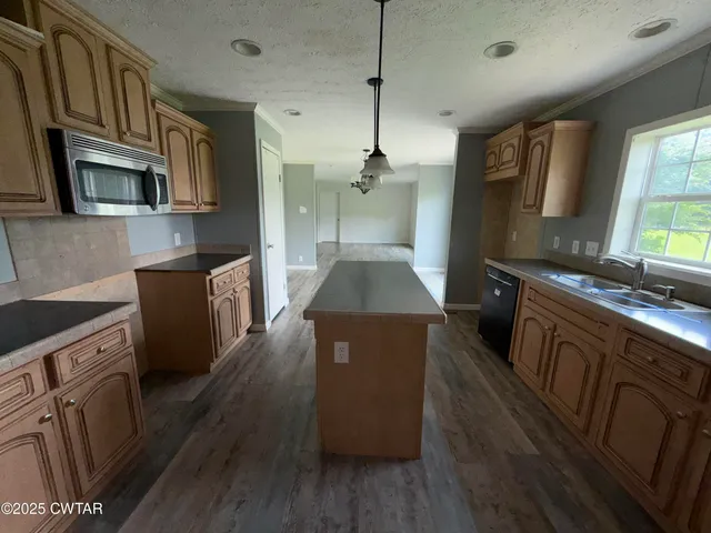 a kitchen with stainless steel appliances granite countertop wooden cabinets a refrigerator a stove a sink and a microwave